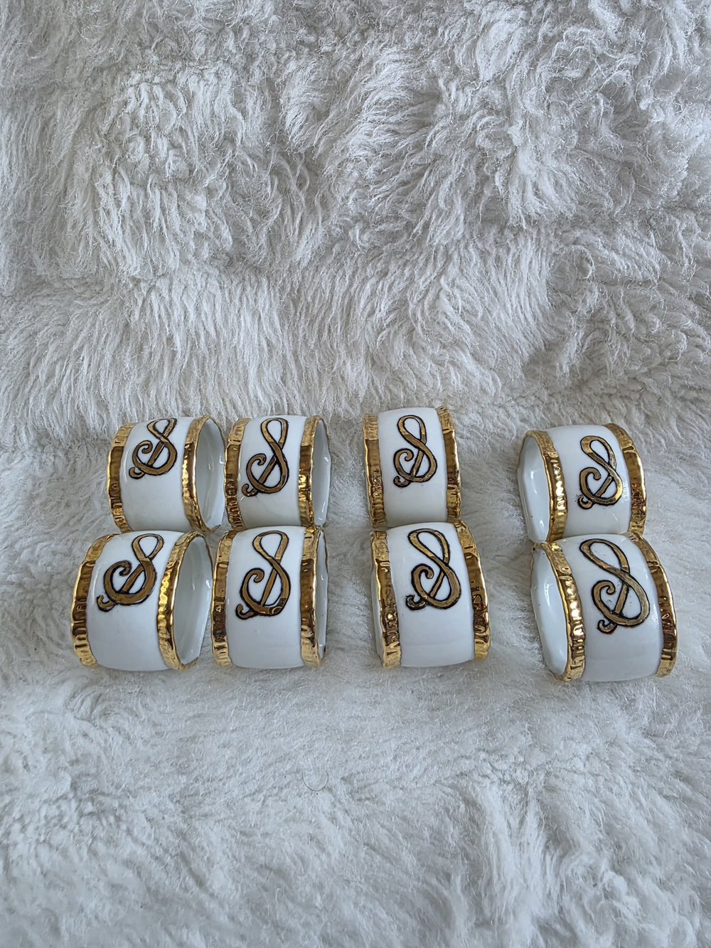Set Of 8 White Porcelain Napkin Rings with Gold Trim and Monogram Accent.